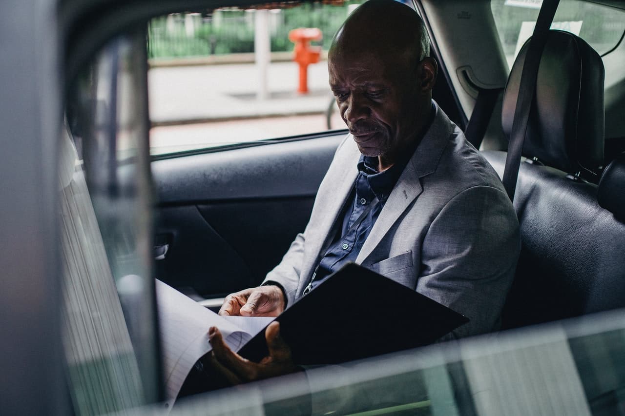 A man looks over documents in his car.