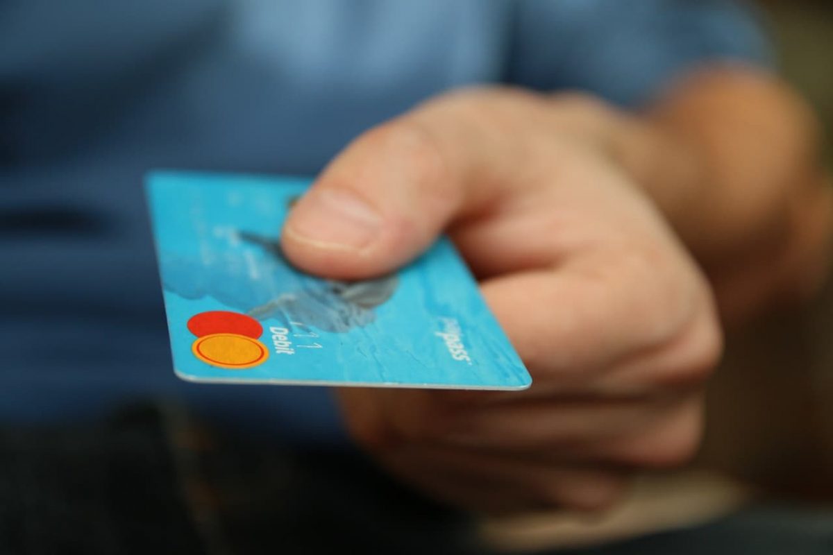 A person hands over their credit card.